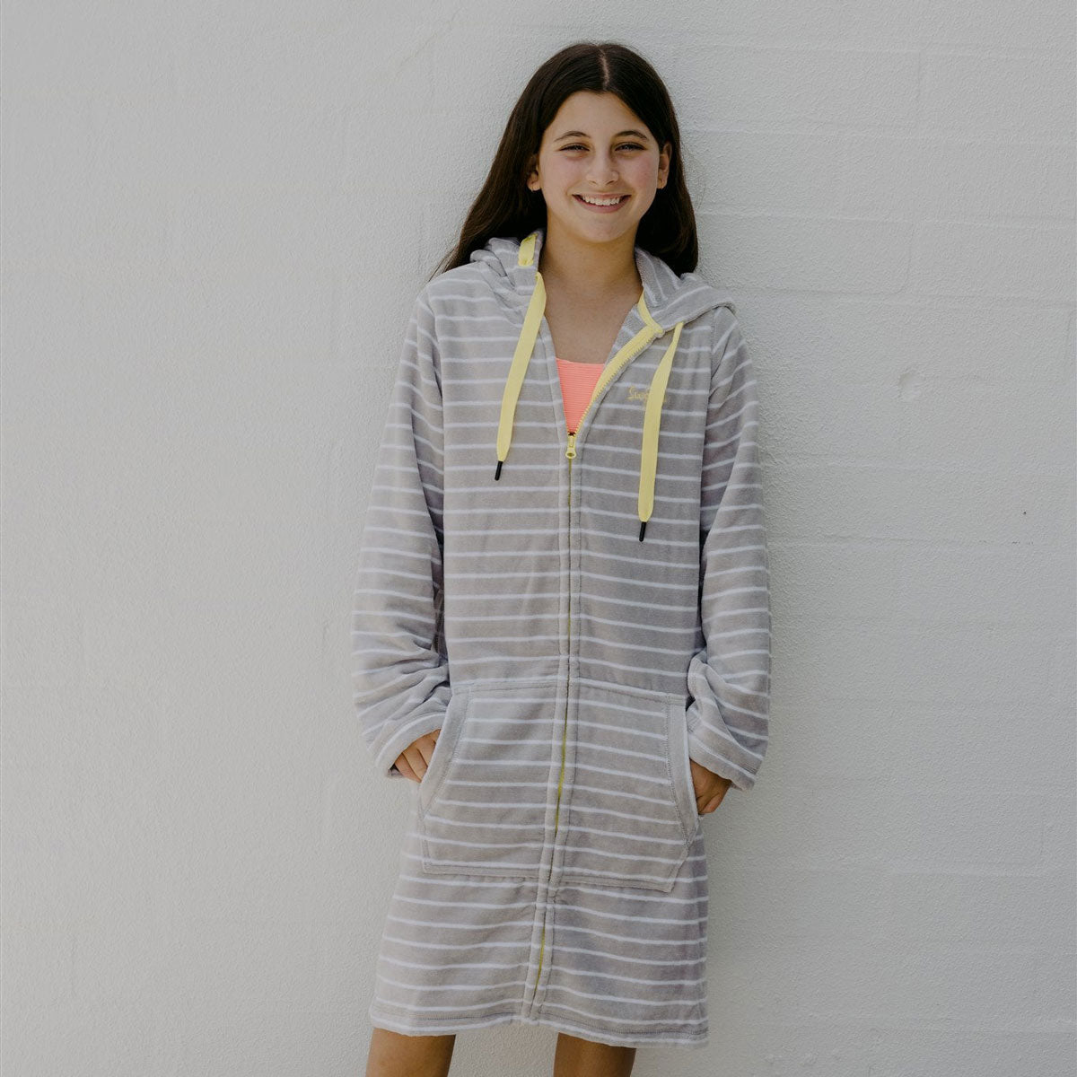 Girl wearing grey with lemon swimming robe standing front on